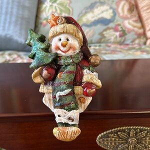 Snowman stocking holder with star on stocking hat.